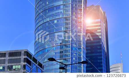 Glass building with transparent facade of the building and blue sky. Structural glass wall reflecting blue sky. Abstract modern architecture fragment. Contemporary architectural background. 123720873