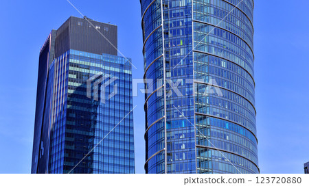 Glass building with transparent facade of the building and blue sky. Structural glass wall reflecting blue sky. Abstract modern architecture fragment. Contemporary architectural background. 123720880