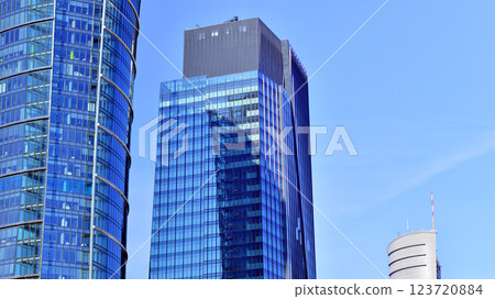 Glass building with transparent facade of the building and blue sky. Structural glass wall reflecting blue sky. Abstract modern architecture fragment. Contemporary architectural background. Glass building with transparent facade of the building and blue sky. Structural glass wall reflecting blue sky. Abstract modern architecture fragment. Contemporary architectural background. 123720884