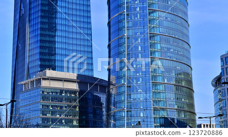 Glass building with transparent facade of the building and blue sky. Structural glass wall reflecting blue sky. Abstract modern architecture fragment. Contemporary architectural background. 123720886
