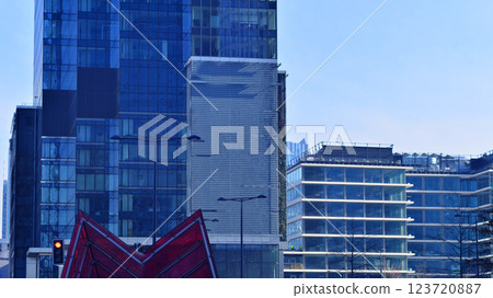 Glass building with transparent facade of the building and blue sky. Structural glass wall reflecting blue sky. Abstract modern architecture fragment. Contemporary architectural background. 123720887