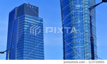 Glass building with transparent facade of the building and blue sky. Structural glass wall reflecting blue sky. Abstract modern architecture fragment. Contemporary architectural background. Glass building with transparent facade of the building and blue sky. Structural glass wall reflecting blue sky. Abstract modern architecture fragment. Contemporary architectural background. 123720893