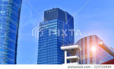 Glass building with transparent facade of the building and blue sky. Structural glass wall reflecting blue sky. Abstract modern architecture fragment. Contemporary architectural background. 123720894