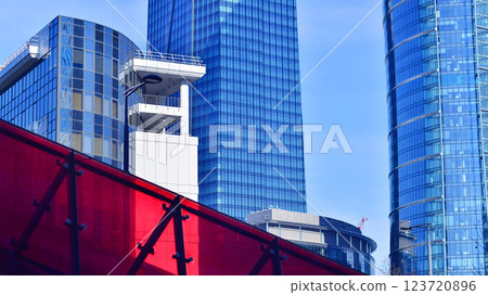 Glass building with transparent facade of the building and blue sky. Structural glass wall reflecting blue sky. Abstract modern architecture fragment. Contemporary architectural background. Glass building with transparent facade of the building and blue sky. Structural glass wall reflecting blue sky. Abstract modern architecture fragment. Contemporary architectural background. 123720896