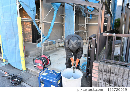 Cleaning the exterior walls with an engine-powered high-pressure washer - exterior wall painting work 123720939