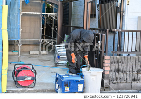 Cleaning the exterior walls with an engine-powered high-pressure washer - exterior wall painting work Cleaning the exterior walls with an engine-powered high-pressure washer - exterior wall painting work 123720941