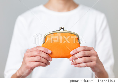 拿著橘色錢包的中年婦女 拿著橘色錢包的中年婦女 123721103