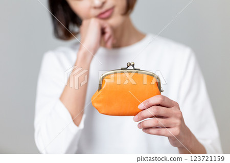 A middle-aged woman worried about her orange wallet 123721159