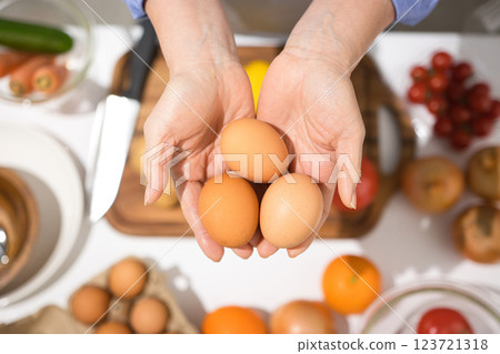 Middle-aged woman's hand holding fresh eggs 123721318