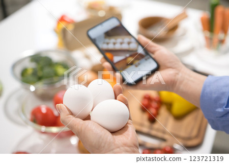 The hands of a middle-aged woman taking pictures of cooking ingredients with her smartphone 123721319