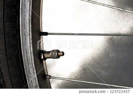 Valve cap removed from a worn bicycle tire Valve cap removed from a worn bicycle tire 123721437