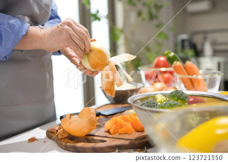 Hands of a middle-aged woman cutting vegetables 123721550