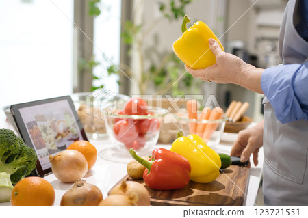 中年婦女一邊看平板電腦一邊做飯 123721551
