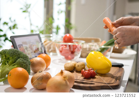 Middle woman cooking while looking at a tablet 123721552
