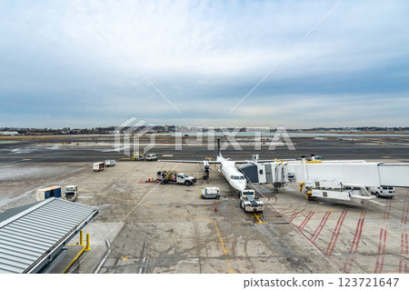 Small commercial aircraft parking at the gate with jetbridge connecting to it for passengers to exit Small commercial aircraft parking at the gate with jetbridge connecting to it for passengers to exit 123721647