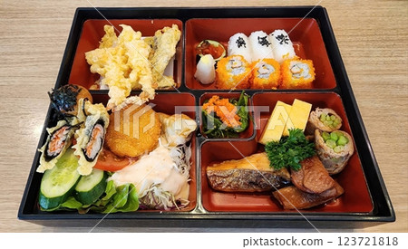 Colorful Japanese Bento Box with Sushi, Tempura, and Fresh Vegetables 123721818