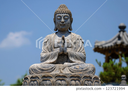 Ancient statue great Buddha on bright holiday composition, abstract vivid composition consists of fictional unreal fantastic vision on background 123721994