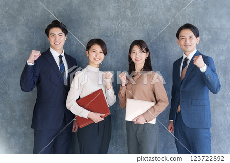 Multiple businessmen, men and women, looking at the camera with a fist pump Multiple businessmen, men and women, looking at the camera with a fist pump 123722892