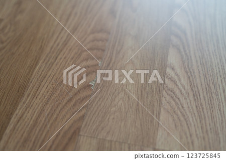 Laminate flooring with visible defects like chips, cracks, and unevenness. 123725845