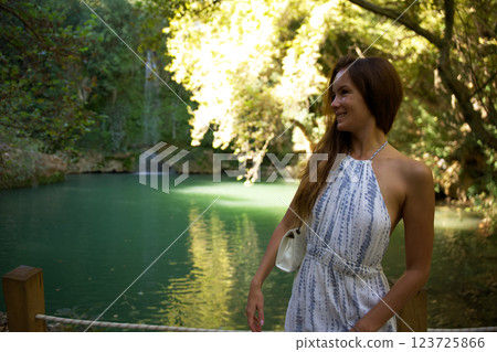 Smiling woman enjoying a scenic forest lake 123725866