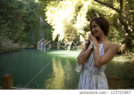 Smiling woman enjoying nature by scenic lake 123725867