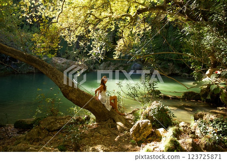 Woman Relaxing by a Forest Waterfall Pool Woman Relaxing by a Forest Waterfall Pool 123725871