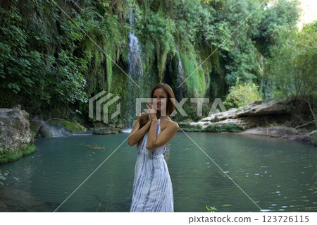 Smiling Woman Enjoying a Peaceful Waterfall and River Smiling Woman Enjoying a Peaceful Waterfall and River 123726115