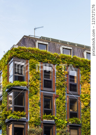 Green Architecture. Modern Building Wrapped in Lush Ivy and Natural Aesthetic Green Architecture. Modern Building Wrapped in Lush Ivy and Natural Aesthetic 123727176