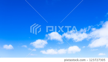 A simple landscape of clear blue sky and white clouds 123727305