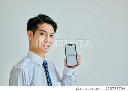 A young man in his 20s holding a smartphone New NISA A young man in his 20s holding a smartphone New NISA 123727704