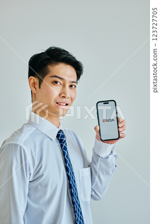 一名 20 多歲的年輕男子手持智慧型手機 新 NISA 123727705