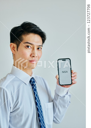 一名 20 多歲的年輕男子拿著智慧型手機 NISA 123727706