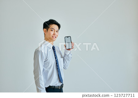 A young man in his 20s holding a smartphone NISA 123727711