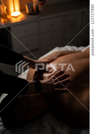 Woman masseuse doing professional back massage to man in spa salon. 123727980