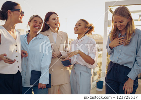 A group of fashionable and stylish women have gathered outside to enjoy a joyful moment together 123728517