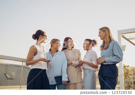 Empowered Women Networking Outdoors in a Vibrant Modern Setting to Foster Connections Empowered Women Networking Outdoors in a Vibrant Modern Setting to Foster Connections 123728530