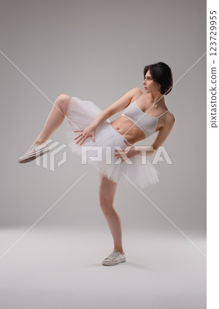 Elegant ballet dancer poses gracefully in lingerie at dance studio setting Elegant ballet dancer poses gracefully in lingerie at dance studio setting 123729955