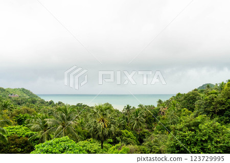Explore the lush greenery and serene seaview of Koh Phangan under a moody sky filled with clouds. 123729995
