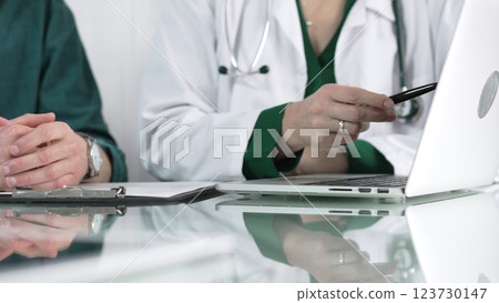 Female doctor showing medical exam results on a laptop to a patient during a visit at the clinic, healthcare and medical consultation concept Female doctor showing medical exam results on a laptop to a patient during a visit at the clinic, healthcare and medical consultation concept 123730147