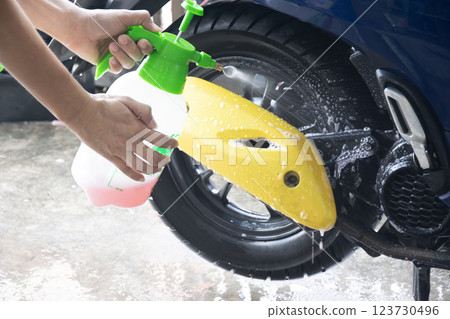 Washing a motorcycle with a stain remover 123730496