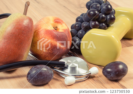 Fresh fruits, dumbbells, stethoscope. Healthy lifestyle and nutrition Fresh fruits, dumbbells, stethoscope. Healthy lifestyle and nutrition 123730530