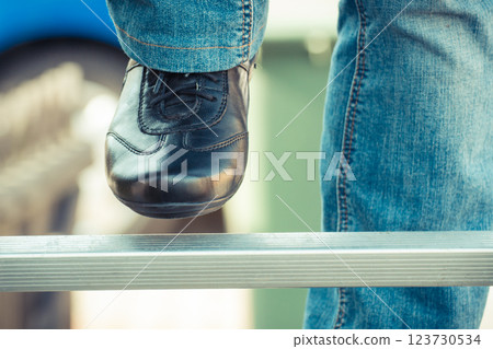 Foot of woman on aluminum ladder in garden Foot of woman on aluminum ladder in garden 123730534