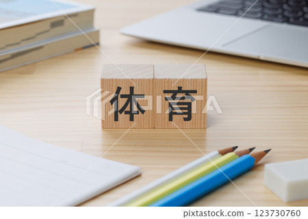 A block with the word "PE" written on it on the desk 123730760