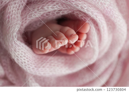Baby foot on pink soft coverlet, blanket.Close-up of tiny, cute, bare toes, heels and feet of a newborn girl, boy.Detail of a newborn baby legs. Macro horizontal professional studio photo.  123730804