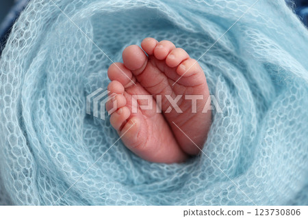 Baby foot on blue soft coverlet, blanket. Close-up of tiny, cute, bare toes, heels and feet of a newborn girl, boy. Baby foot on blue soft coverlet, blanket. Close-up of tiny, cute, bare toes, heels and feet of a newborn girl, boy. 123730806