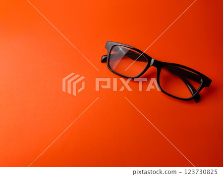 Black glasses on a orange background with copy space. Black glasses on a orange background with copy space. 123730825