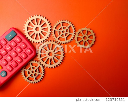 Top view green calculator with wooden gear on a orange background. Business concept. Top view green calculator with wooden gear on a orange background. Business concept. 123730831