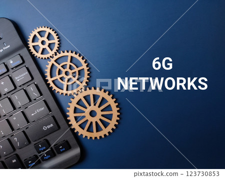 Wooden gear and keyboard with the word 6G NETWORKS on a blue background. 123730853