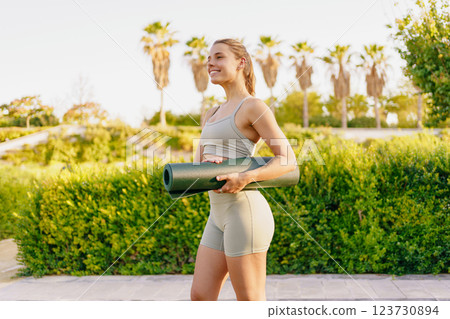 A Fitness Enthusiast Carrying a Colorful Yoga Mat While Enjoying Natures Beauty 123730894