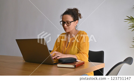 Entrepreneur Working Remotely From Home Using Laptop in Modern Cozy Interior Entrepreneur Working Remotely From Home Using Laptop in Modern Cozy Interior 123731147